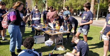 group of students, standing around a table