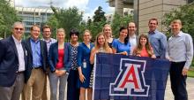 A group of people posing together with a UA flag