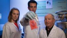 Three doctors posing with a sample of tissue