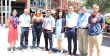 Eight new engineering faculty members stand in the AME courtyard wearing festive leis