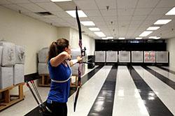 Sophomore Madison Eich aims at a target at the PSE Archery range. Photo by Darien Bakas / The Daily Wildcat
