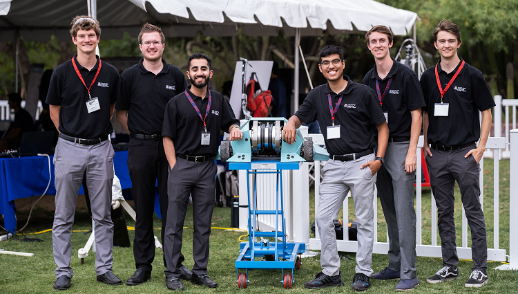 The six students of Team 23037 at Craig M. Berge Design Day, posing with their battle robot