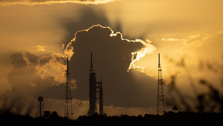 NASA’s Space Launch System rocket with the Orion spacecraft aboard in front of a sunset