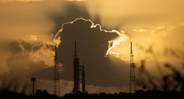 NASA’s Space Launch System rocket with the Orion spacecraft aboard in front of a sunset