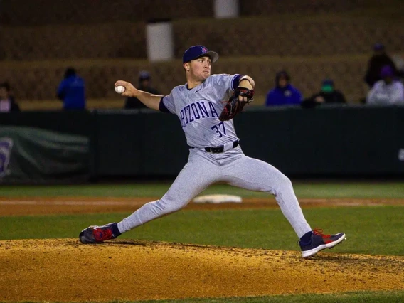 A baseball pitcher on the pitchers mound throws a baseball