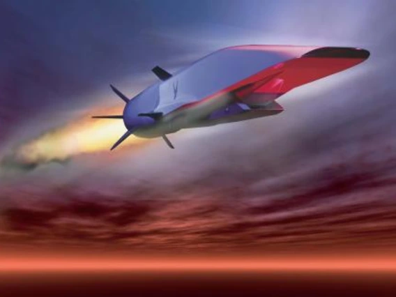 A silver vehicle flys through the sky.