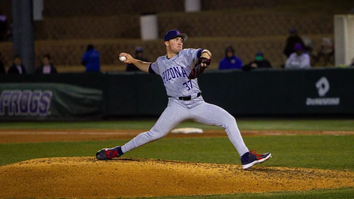 A baseball pitcher on the pitchers mound throws a baseball