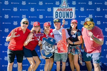 Engineering Wildcat alumni holding SWAG items