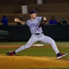 A baseball pitcher on the pitchers mound throws a baseball